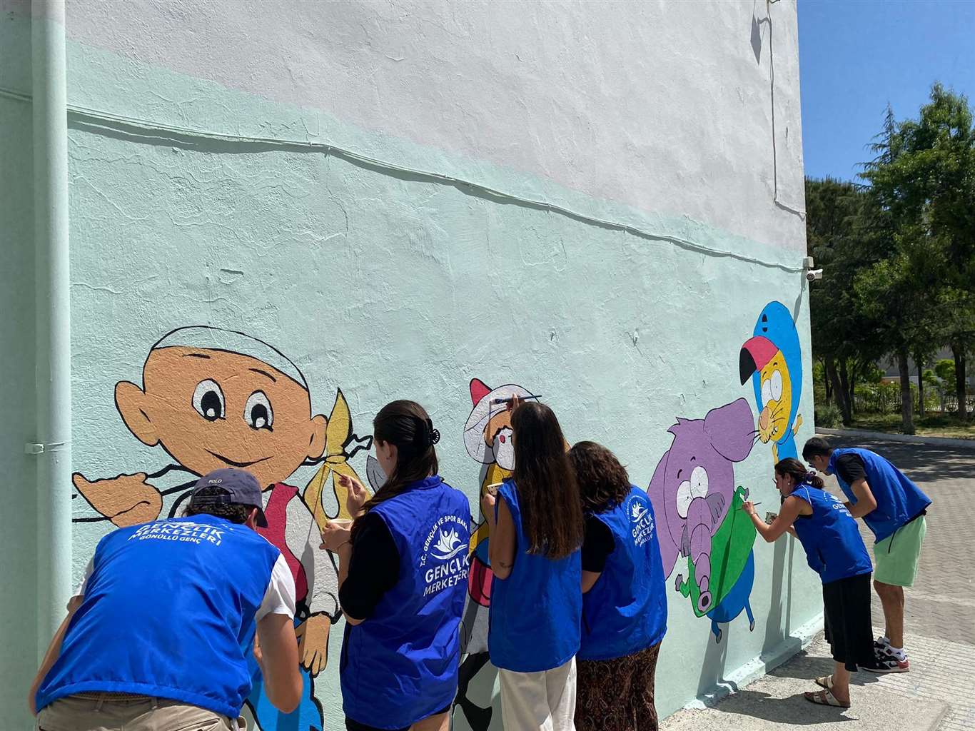    Gönüllü gençler okul duvarlarına masal kahramanlarını resmediyor haberi